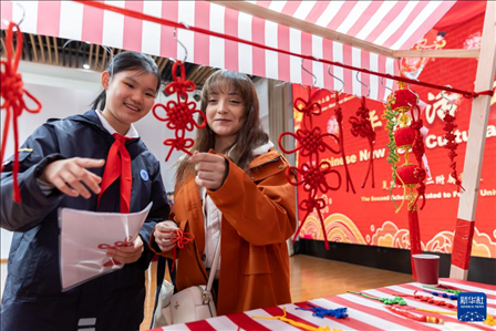 1月28日，復(fù)旦大學(xué)第二附屬學(xué)校學(xué)生（左）為美國馬斯卡廷中學(xué)學(xué)生（右）介紹中國結(jié)。 新華社記者 王翔 攝