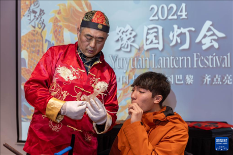 1月28日，在上海豫園舉行的民俗活動上，美國馬斯卡廷中學(xué)學(xué)生在非遺傳承人的指導(dǎo)下吹糖偶。 新華社記者 王翔 攝