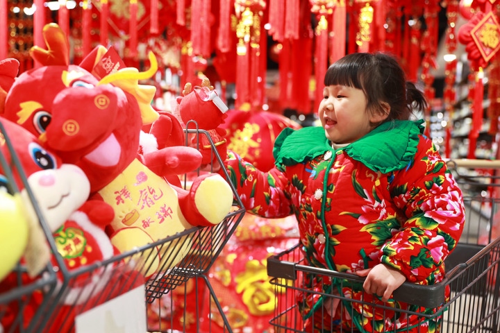 1月23日，在貴州省黔東南苗族侗族自治州岑鞏縣一家超市，小朋友在家人的帶領(lǐng)下選購龍年毛絨玩具。新華社發(fā)（唐鵬攝）