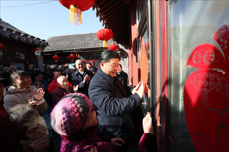 2019年2月1日上午，習近平總書記在前門東區(qū)草廠四條胡同32號院，高興地拿起一幅“?！弊郑H自貼到門上，給這里的老街坊們拜年。新華社記者鞠鵬攝