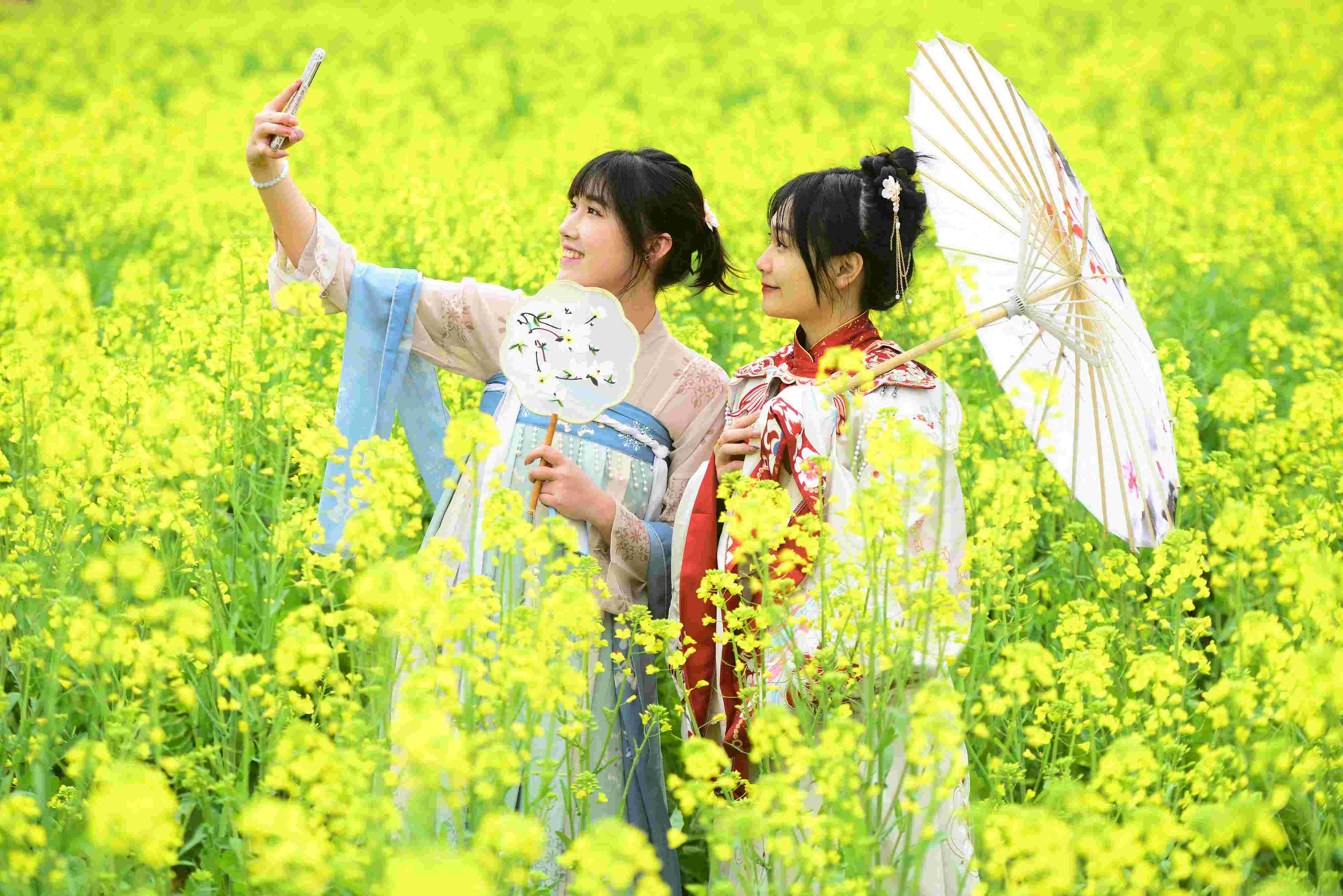 △ 2024年2月16日，廣西賀州，在富川瑤族自治縣麥嶺鎮(zhèn)三民村，游客在油菜花田間賞花拍照。