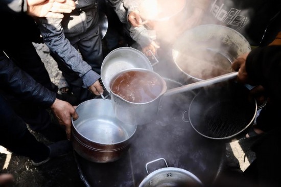  2月27日，在加沙地帶北部的杰巴利耶難民營，人們領(lǐng)取食物。新華社發(fā)（穆罕默德·阿里攝）
