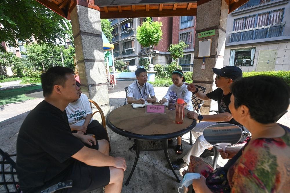 △2023年7月21日，在位于浙江杭州臨安區(qū)錦南街道水岸陽光小區(qū)的陽光議事廳，街道干部在聽取居民們反映的問題及意見。