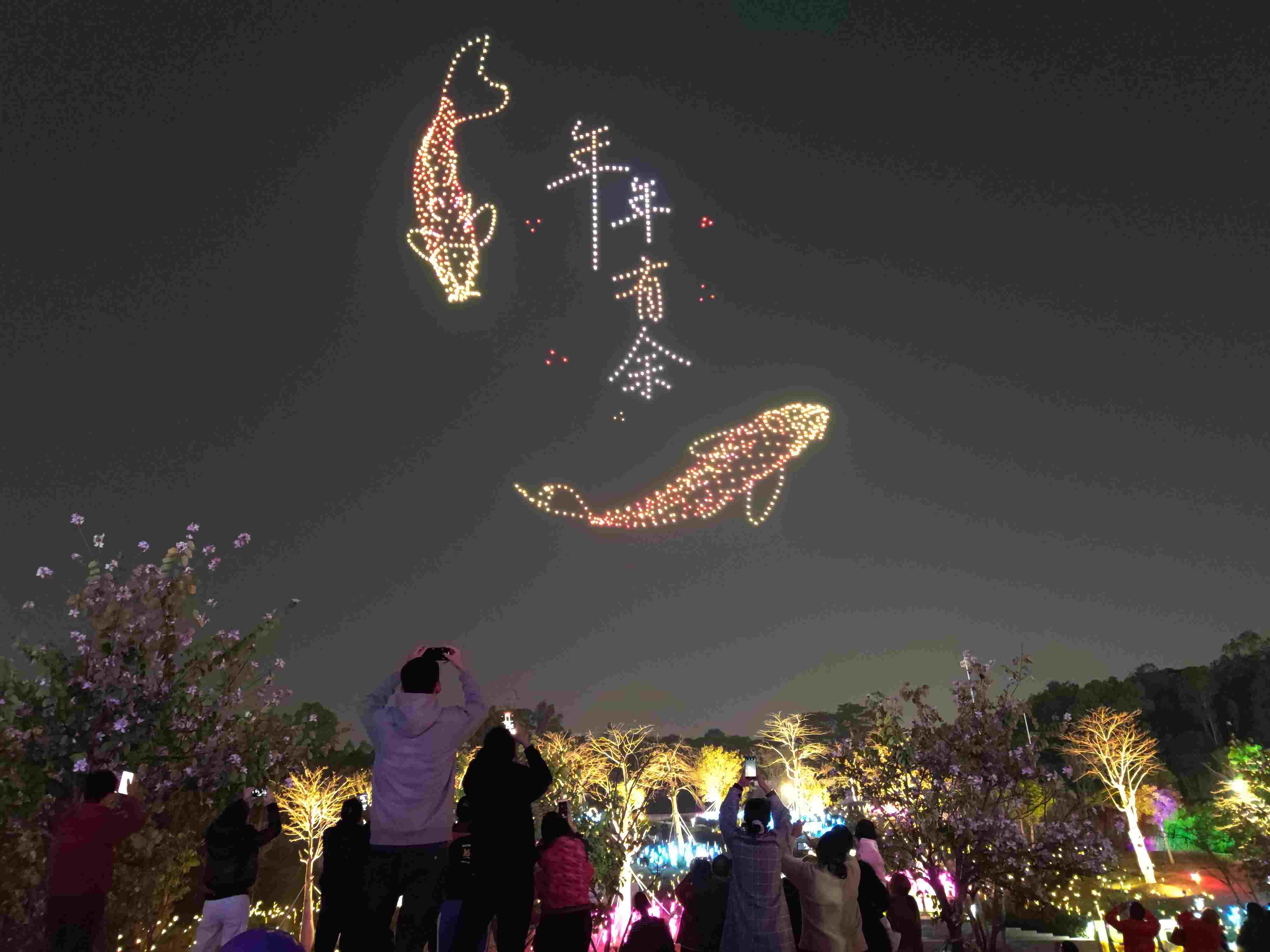 △ 2024年2月10日，深圳北站中心公園，春節(jié)主題無人機(jī)燈光秀引來眾多游客駐足觀看。