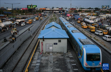 3月4日，在尼日利亞拉各斯，一列輕軌藍(lán)線列車行駛至公路交通擁堵路段附近。新華社記者 韓旭 攝