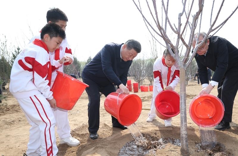 2024年4月3日，習(xí)近平總書記同少先隊(duì)員一起給剛栽下的樹苗澆水。