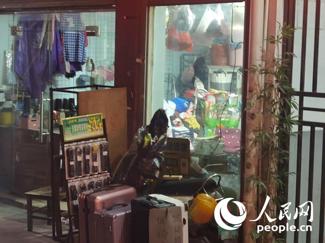 南寧“城中村”一裁縫鋪老板將電線從店內(nèi)拉出為電動自行車充電。人民網(wǎng) 覃心攝