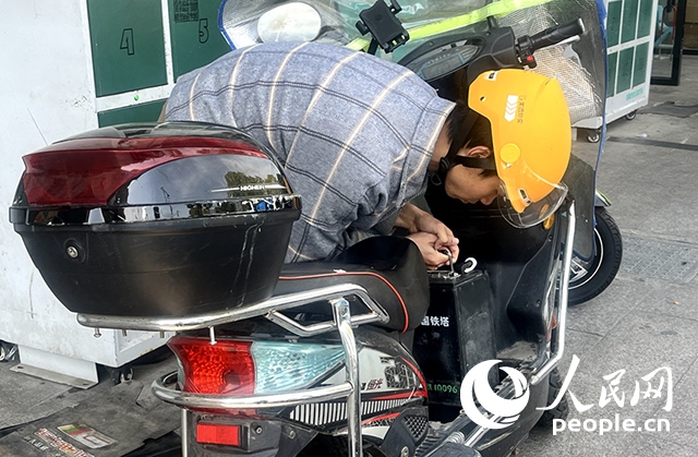 杭州一名外賣騎手正在更換共享電池。人民網(wǎng)記者 張麗瑋攝