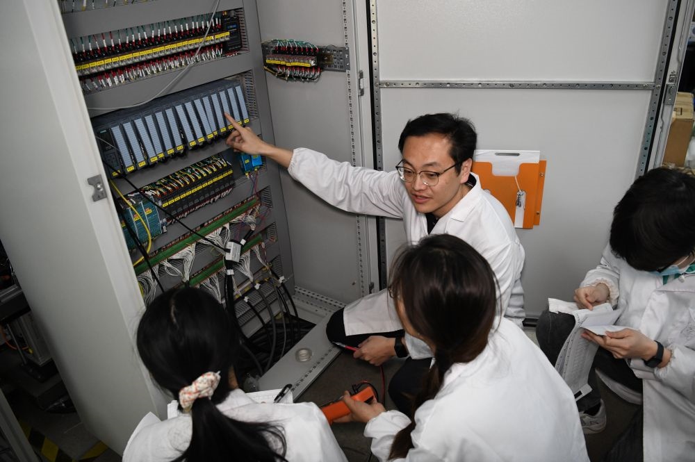 2024年4月6日，在位于安徽合肥的中國(guó)科學(xué)技術(shù)大學(xué)，安徽省先進(jìn)功能高分子薄膜工程實(shí)驗(yàn)室團(tuán)隊(duì)成員在檢修自主研制的高分子薄膜原位雙向拉伸實(shí)驗(yàn)設(shè)備的電氣控制系統(tǒng)。