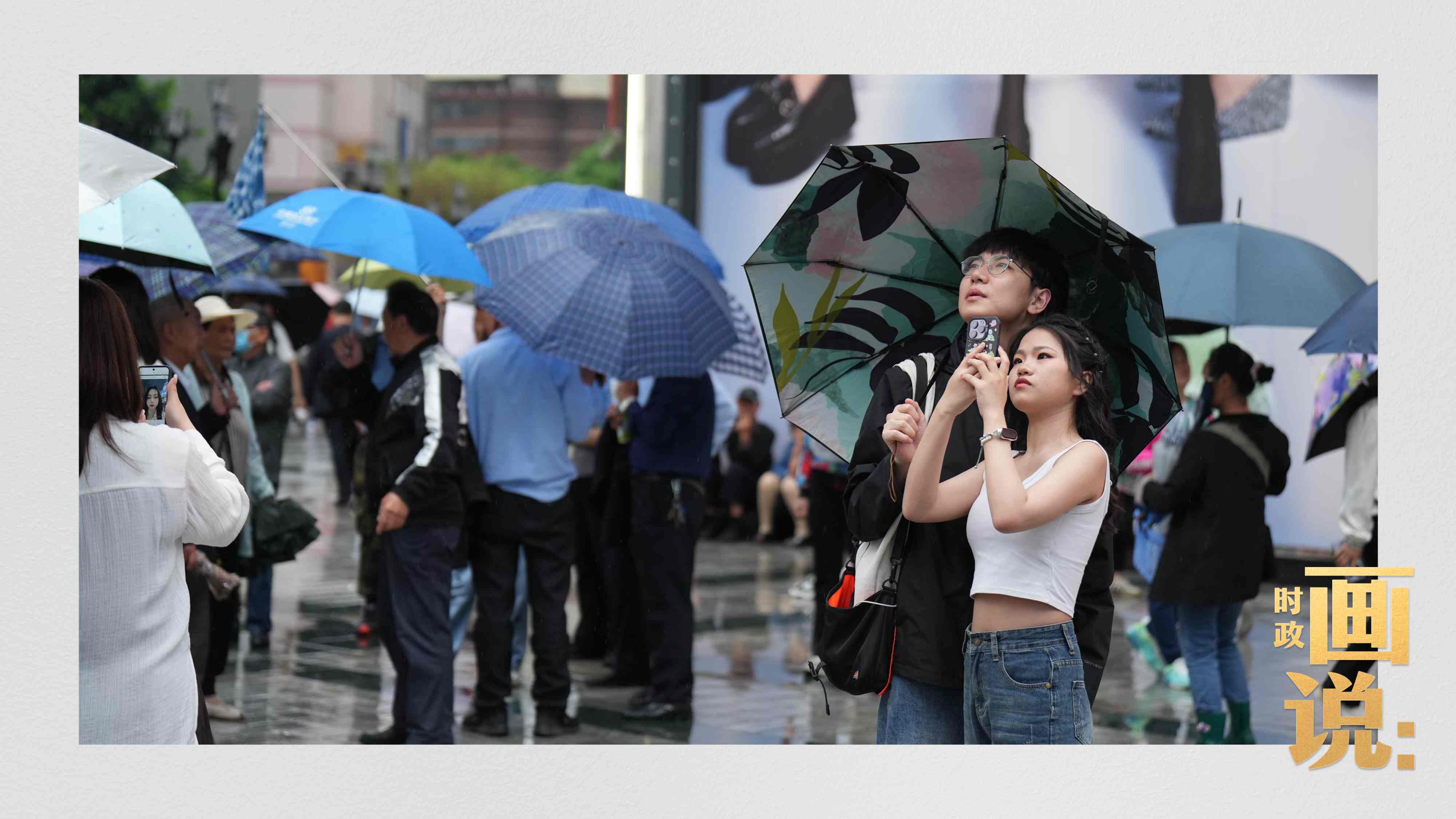 △細(xì)雨中的解放碑步行街，騎在父親肩膀的小女孩好奇張望。