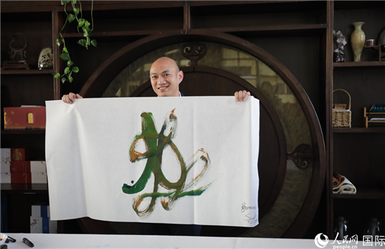 老撾駐華大使館三秘明君參加《五百筆·瀾湄合作》集體藝術(shù)創(chuàng)作。人民網(wǎng)王婧攝。