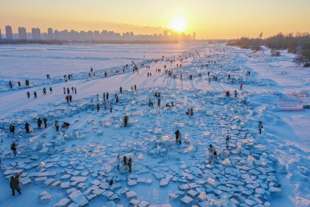 2024年1月7日，在封凍的松花江哈爾濱段，游客在日落時分的“鉆石海”游玩（無人機(jī)照片）。新華社記者 謝劍飛 攝