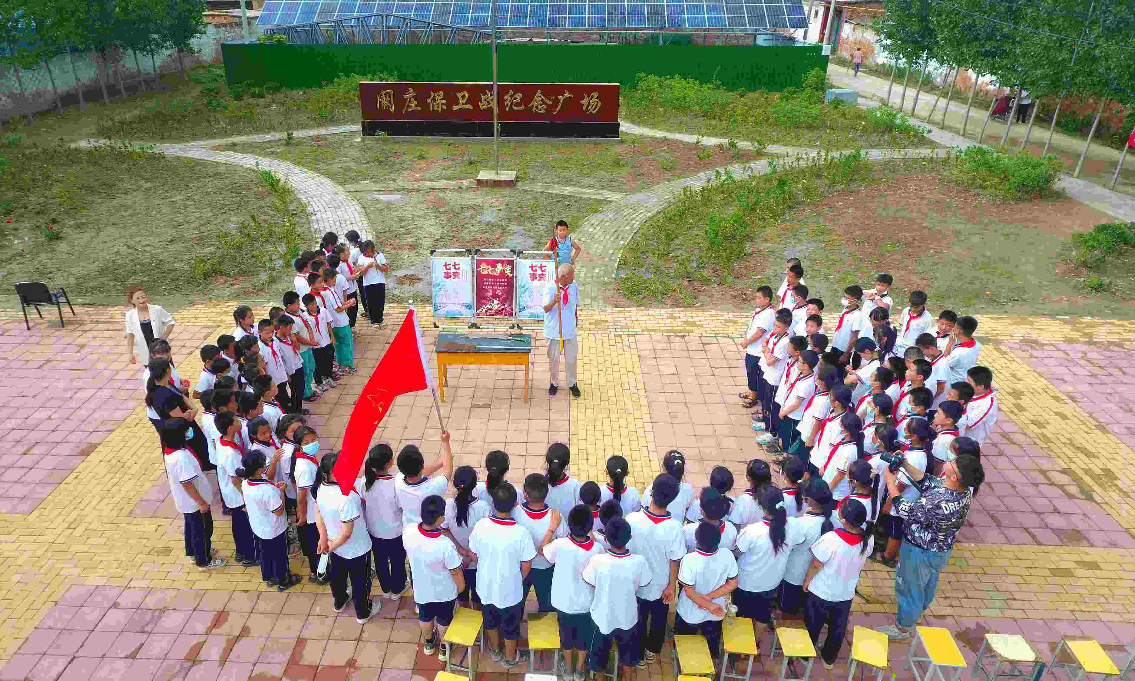 2022年7月6日，山東省聊城市，在茌平區(qū)菜屯鎮(zhèn)闞莊村的闞莊保衛(wèi)戰(zhàn)紀(jì)念廣場(chǎng)，闞莊保衛(wèi)戰(zhàn)親歷者王光木老人為小學(xué)生們講述抗戰(zhàn)故事，展示大刀、長(zhǎng)矛。