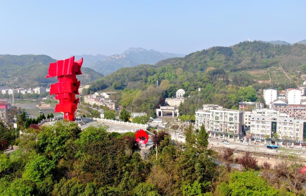 這是2021年4月9日拍攝的鄂豫皖蘇區(qū)首府革命博物館附近的英雄山上的“紅旗飄飄”主題雕塑（無人機照片）。新華社發(fā)