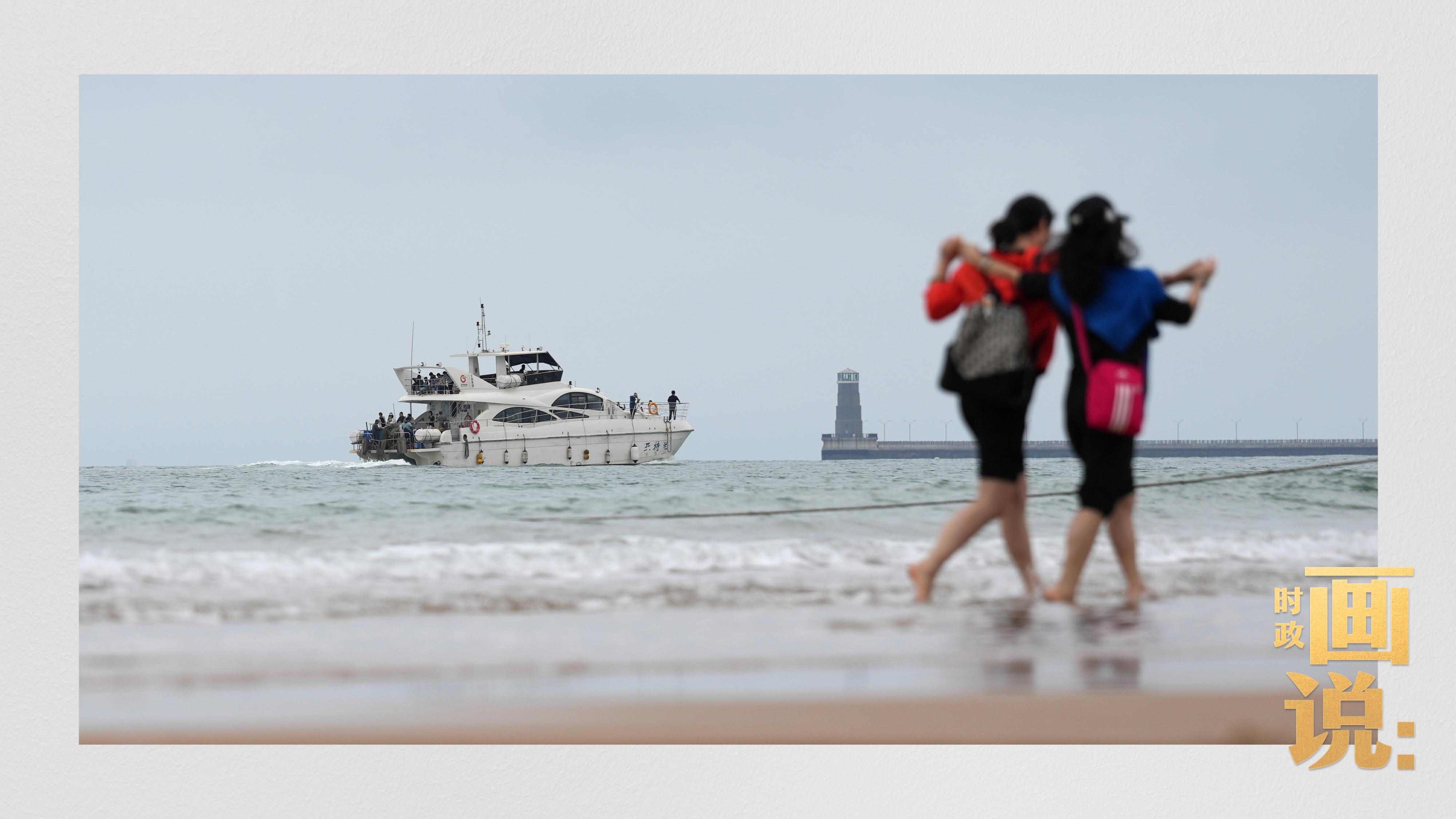 △日照陽光海岸綠道上的萬平口景區(qū)，一對游客在海浪中翩然起舞。