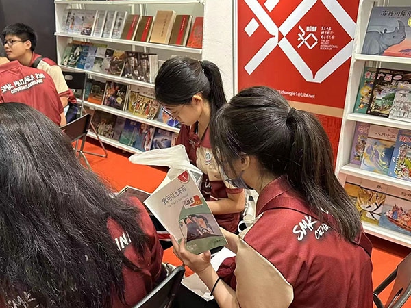 馬來西亞讀者在中國聯(lián)合展臺翻閱中國書籍。 中國圖書進出口（集團）有限公司供圖