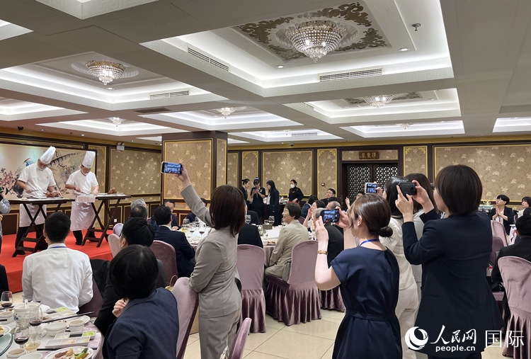 國家級非物質(zhì)文化遺產(chǎn)、全聚德片鴨工藝吸引代表團成員拍照留念。
