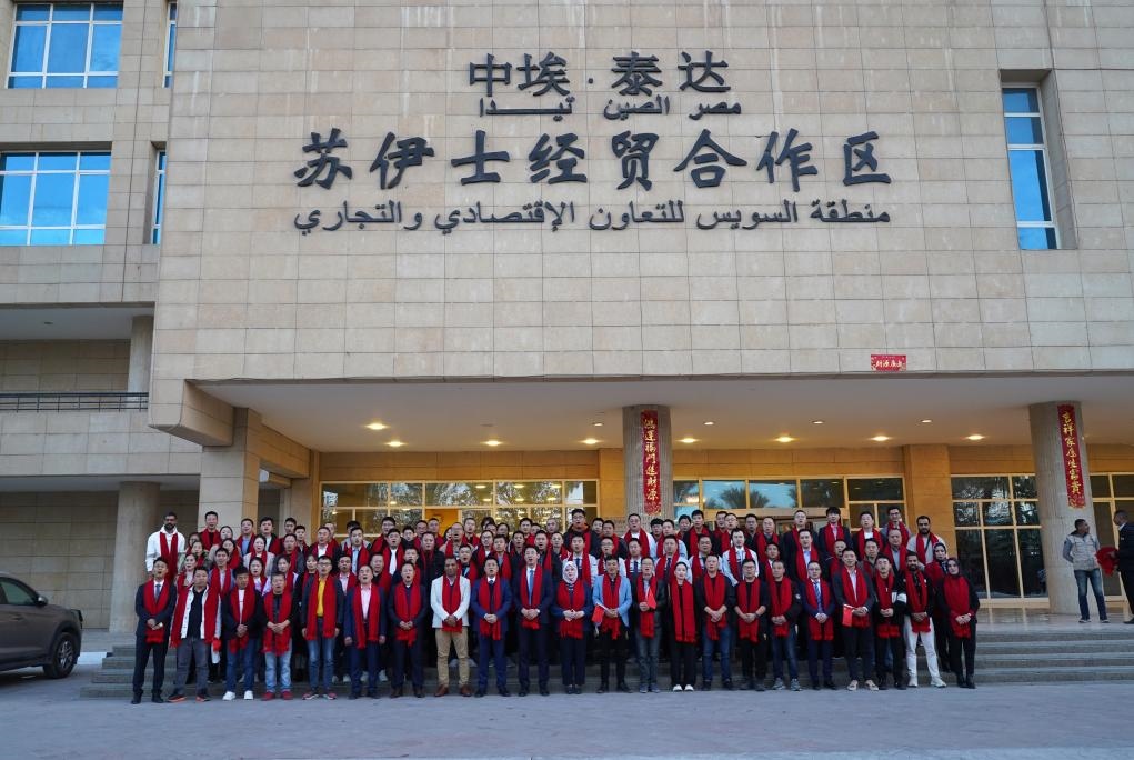 2024年2月11日，在位于埃及蘇伊士省的中?！ぬ┻_(dá)蘇伊士經(jīng)貿(mào)合作區(qū)，中埃員工在合作區(qū)辦公大樓前合影拜年。新華社發(fā)（泰達(dá)合作區(qū)供圖）