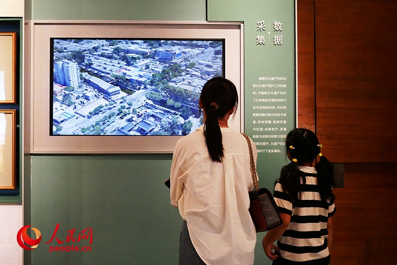 家長(zhǎng)正在帶孩子參觀“輝煌中軸”專(zhuān)題展。人民網(wǎng)記者 韋衍行攝