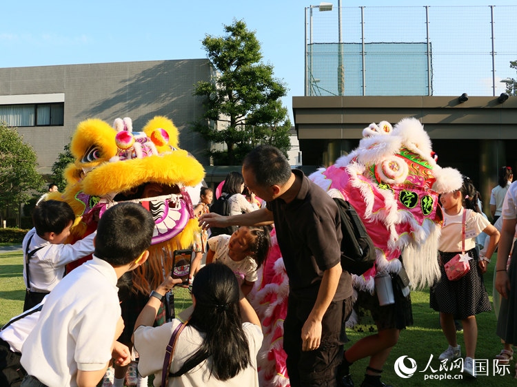 孩子們好奇地圍觀舞獅。人民網(wǎng) 許可攝