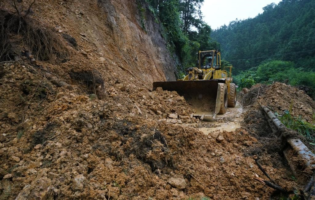 6月18日，在廣西融水苗族自治縣融水鎮(zhèn)新安村，一臺推土機在清理塌方路段。新華社發(fā)（龍林智攝）