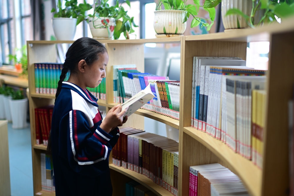 6月18日，果洛西寧民族中學(xué)學(xué)生尼東拉毛在圖書室看書。