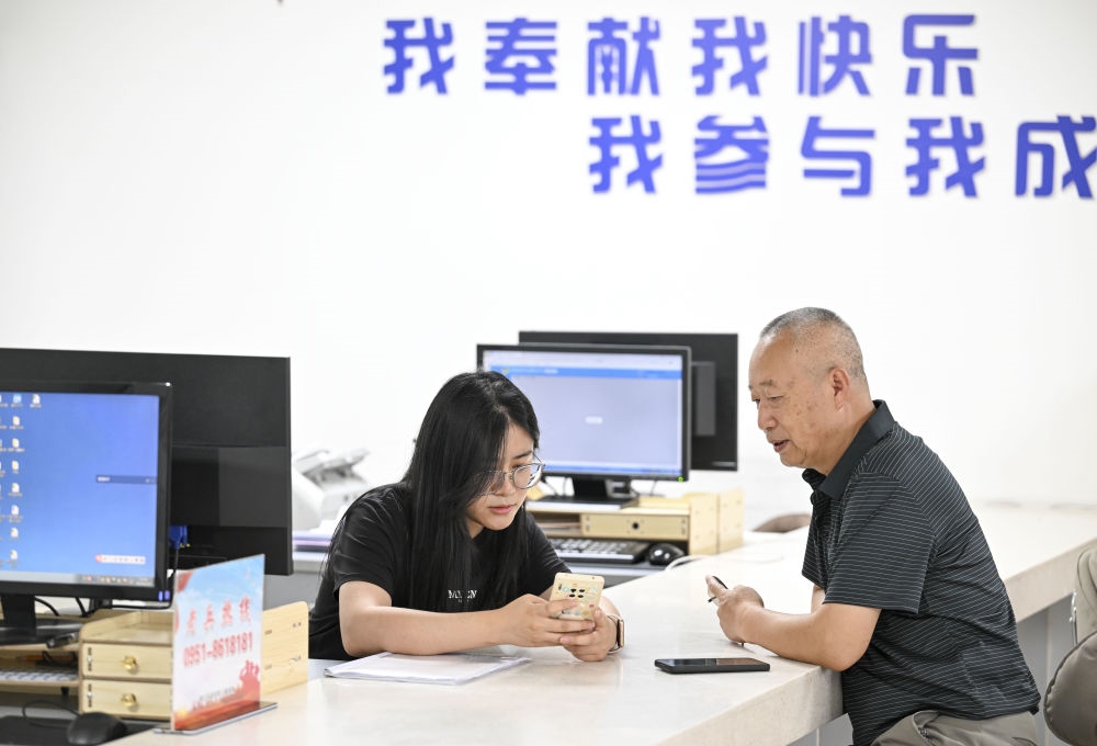6月20日，在長(zhǎng)城花園社區(qū)黨群服務(wù)中心，工作人員幫助居民辦理業(yè)務(wù)。