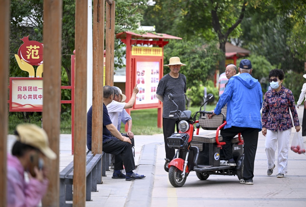 6月20日，長(zhǎng)城花園社區(qū)的居民在休閑、聊天。