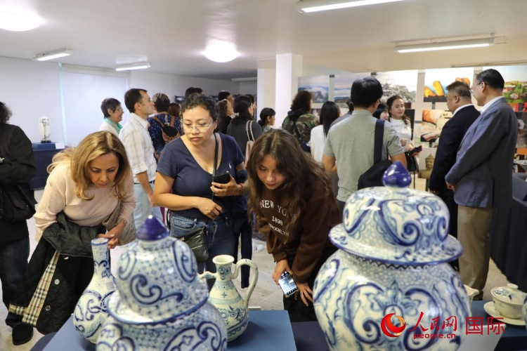 在展覽現(xiàn)場(chǎng)，觀眾們駐足欣賞德化瓷和墨西哥彩瓷。人民網(wǎng) 埃內(nèi)斯托·多明戈斯攝