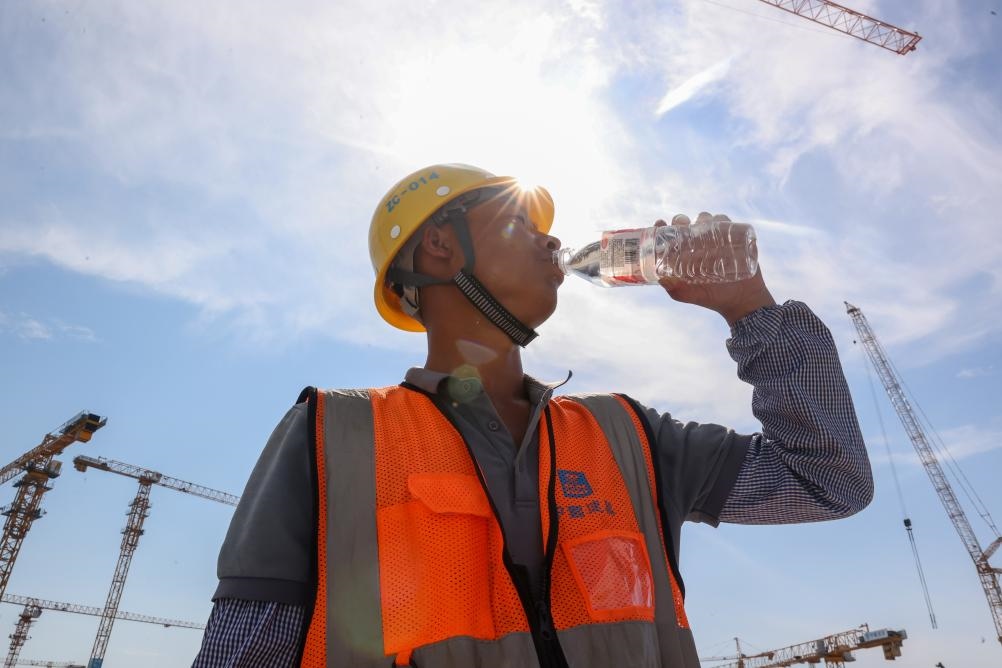 6月18日，在江蘇省無錫市奧體三期項(xiàng)目施工現(xiàn)場，中建二局工人在喝水解暑。新華社發(fā)（朱吉鵬 攝）