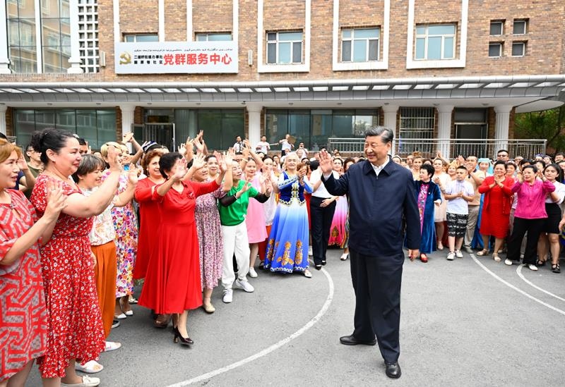 2022年7月13日，習(xí)近平總書(shū)記在新疆烏魯木齊市天山區(qū)固原巷社區(qū)考察時(shí)，向各族群眾揮手致意。