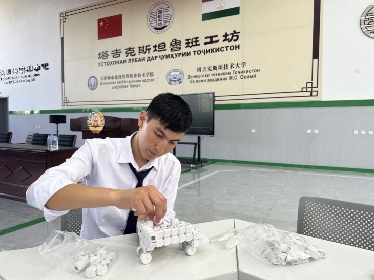 在塔吉克斯坦魯班工坊內(nèi)，學員正在操作能力源創(chuàng)新套件。本報記者 屈佩 攝