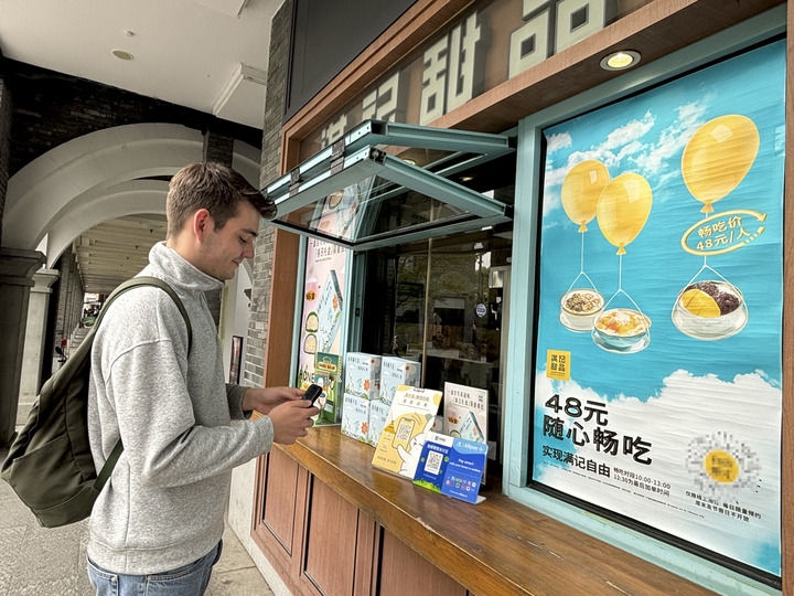 來自德國的留學生理查德在杭州西湖邊一家商鋪使用支付寶掃碼支付（2024年4月11日攝）。新華社發(fā)