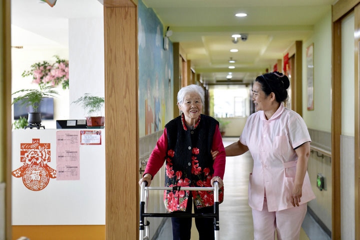 2024年5月25日，在山東省日照市東港區(qū)石臼街道日照幸福護(hù)理院，工作人員在陪護(hù)老人。新華社記者 郭緒雷 攝