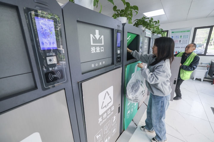 2024年4月10日，在浙江省湖州市吳興區(qū)飛英街道新華府小區(qū)內(nèi)，居民在垃圾分類智能系統(tǒng)的指導(dǎo)下進(jìn)行垃圾分類投放，居民的投放情況將實時匯總到智慧服務(wù)平臺，會有相應(yīng)的積分獎勵。新華社記者 徐昱 攝