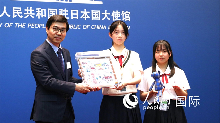 日本小大使向中國駐日本大使館臨時(shí)代辦施泳贈(zèng)送當(dāng)?shù)靥厣Y品。人民網(wǎng) 許可攝