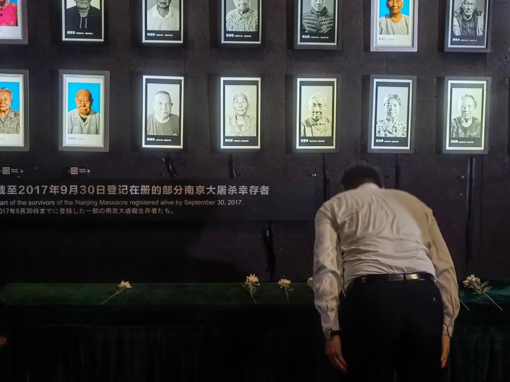 7月18日，人們向離世的南京大屠殺幸存者獻(xiàn)花、鞠躬。新華社記者邱冰清 攝