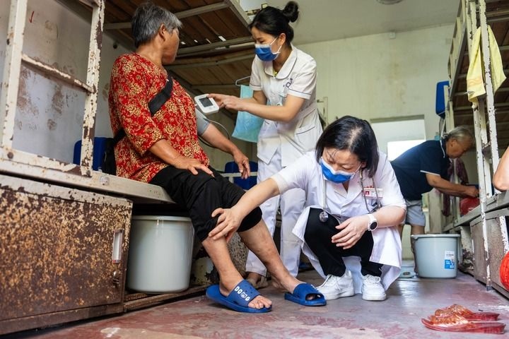 2024年7月30日，在湖南省湘潭縣河口中學(xué)安置點(diǎn)，醫(yī)務(wù)人員為受洪水影響而轉(zhuǎn)移安置的群眾檢查身體。 新華社記者 陳思汗 攝
