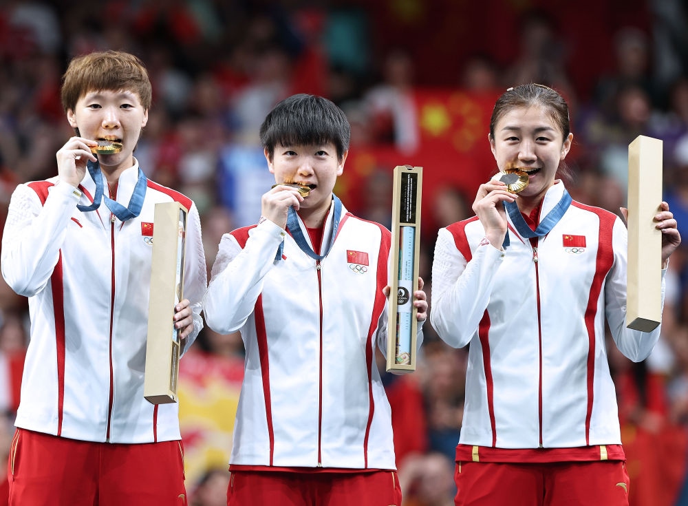冠軍中國隊選手王曼昱、孫穎莎、陳夢（從左至右）在巴黎奧運(yùn)會乒乓球女子團(tuán)體頒獎儀式上（2024年8月10日攝）。新華社記者 王東震 攝