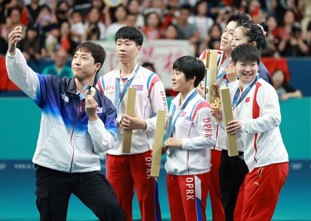 冠軍中國組合王楚欽（右三）/孫穎莎（右一）、亞軍朝鮮組合李正植（左二）/金琴英（左三）、季軍韓國組合林鐘勛（左一）/申裕斌在巴黎奧運(yùn)會乒乓球混雙頒獎儀式上合影（2024年7月30日攝）。新華社記者 劉續(xù) 攝