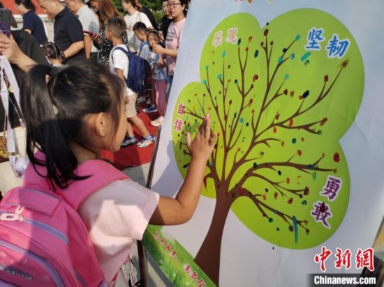 圖為衡水市利民路小學(xué)，孩子們?cè)诔砷L(zhǎng)樹(shù)的“好習(xí)慣”樹(shù)枝上按手印做出承諾。張松 攝