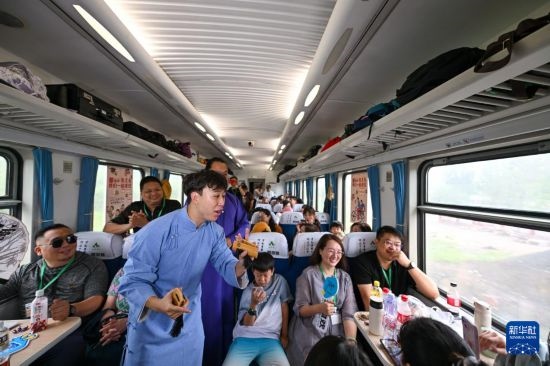 9月7日，相聲演員在S910列車上為旅客表演快板。