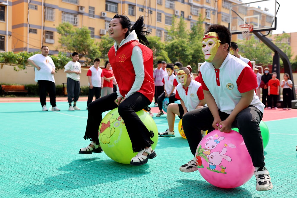 2024年5月17日，在山東省棗莊市市中區(qū)特殊教育中心，青年志愿者與智力障礙學(xué)生一起做游戲。新華社發(fā)（孫中喆攝）