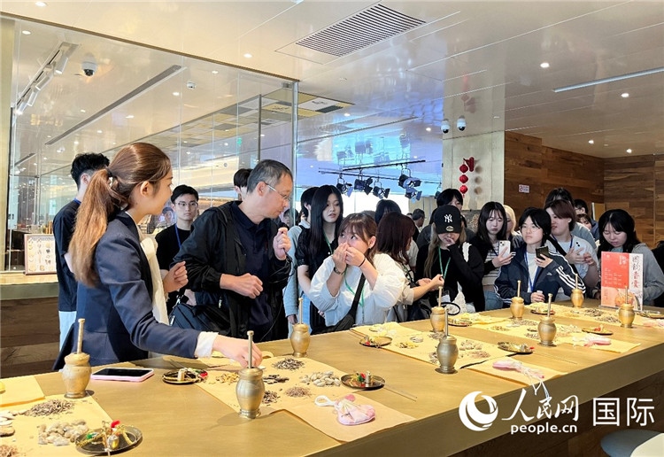 1. 日中友好協(xié)會青年代表團(tuán)一行學(xué)習(xí)中醫(yī)香囊制作工序。（人民網(wǎng)記者陳思 攝）