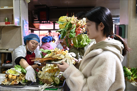 游客挑選好麻辣燙菜品后排隊(duì)等待加工。新華社記者 范培珅 攝