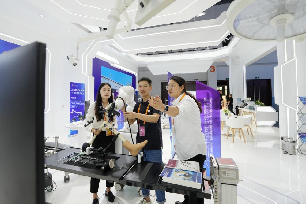 9月11日，一位媒體記者（中）在2024年服貿(mào)會(huì)國家會(huì)議中心會(huì)場體驗(yàn)北京納通科技集團(tuán)有限公司的膝關(guān)節(jié)置換手術(shù)機(jī)器人。新華社記者鞠煥宗 攝