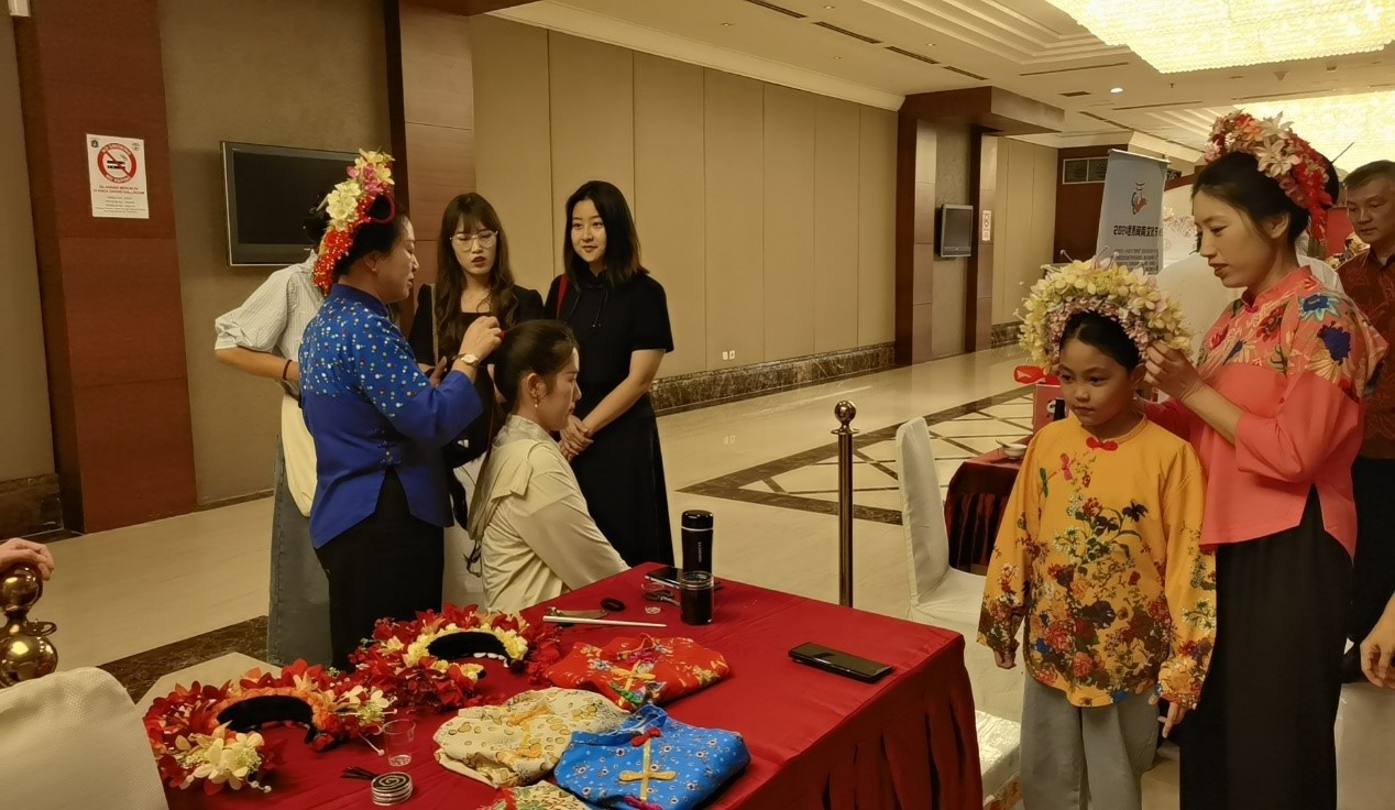阿拉扎大學(xué)孔子學(xué)院志愿者老師向傳承人學(xué)習(xí)簪花圍。阿拉扎大學(xué)孔子學(xué)院供圖