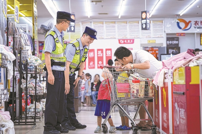 ?8月27日，貴州省凱里市公安局組織開展拉網式大排查，民警在超市和群眾交流。周國輝攝