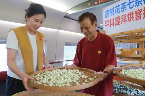10月1日，福州市茉莉花茶窨制工藝代表性傳承人張子建與旅客在G1634次列車上制作茉莉花茶。新華社記者周義 攝