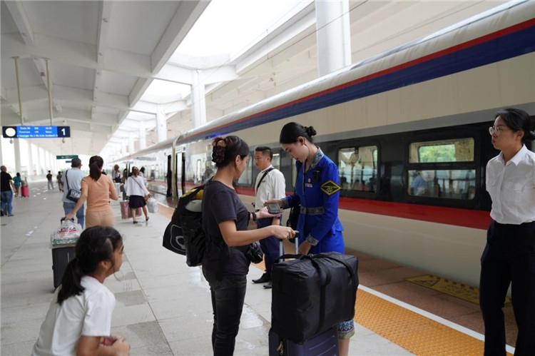 中老鐵路工作人員在站臺(tái)指引旅客進(jìn)站乘車。老中鐵路有限公司供圖